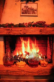 ein flackerndes Kaminfeuer verbreitet Gemütlichkeit (wenn auch nur sicherheitshalber auf Monitor) in der Münchner Weinstub'n auf dem Münchner Christkindlmarkt 2019 (©Foto: Marikk-Laila Maisel)
